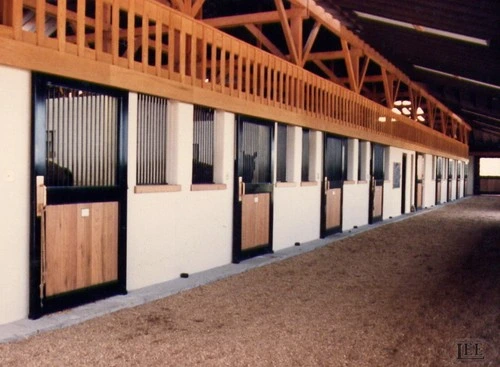 Evening view of stall fronts with warm wood tones and vertical bar doors