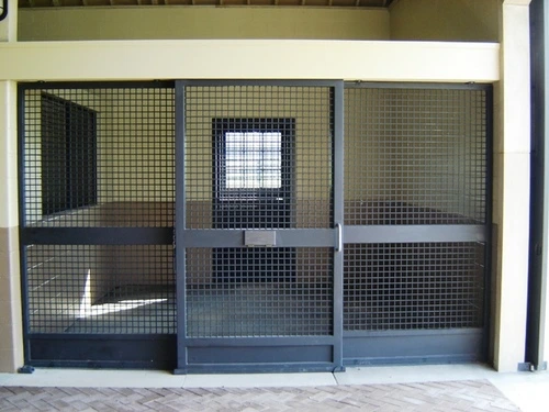A sliding stall door with dark metal frames and wire mesh