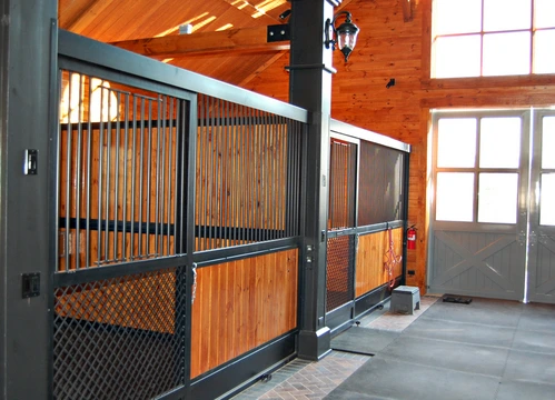 Sage green stall fronts with natural wood lower panels and wire mesh sliding doors