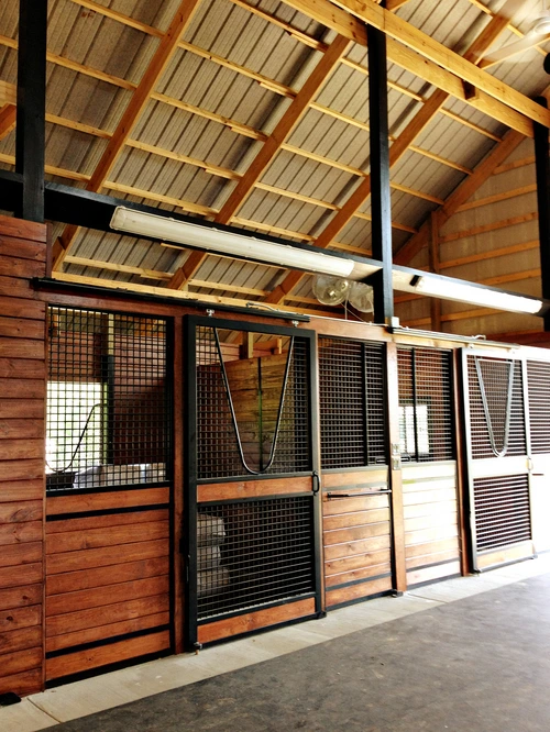 Mahogany horizontal plank stall walls with wire mesh upper sections and decorative rope swags