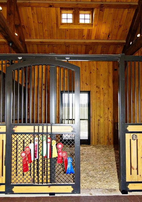 Black metal stall front with natural pine lower section and wire mesh door with circular cutout