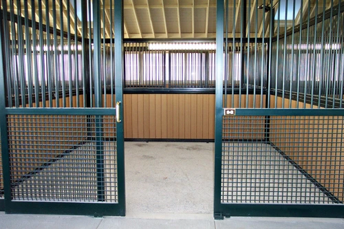 Teal powder-coated stall fronts with natural pine lower panels and wire mesh doors