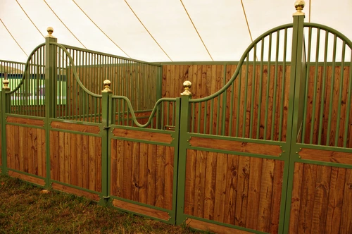 Sage green powder-coated stall fronts with natural pine lower panels and arched upper grills