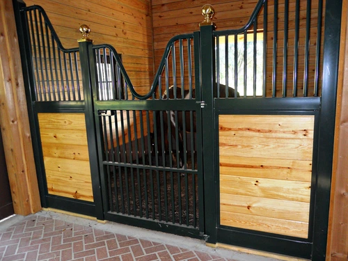 Forest green stall front with natural pine lower panel and black vertical bar upper grill in corner view
