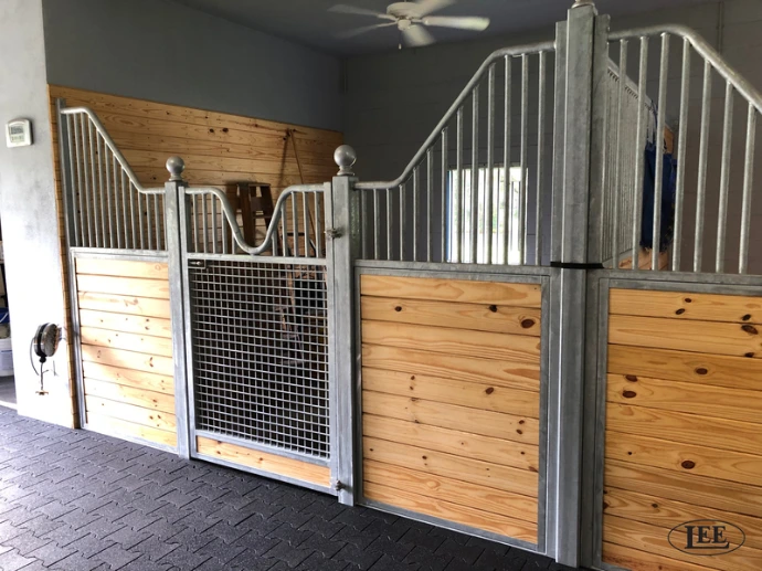 Natural pine stall fronts with black metal vertical bar upper grills and wire mesh door panel visible