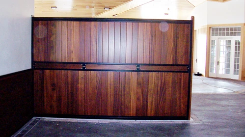 Dark mahogany vertical plank stall front with black horizontal bar upper section in white interior