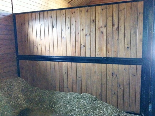 Solid natural wood vertical plank stall wall section in outdoor setting