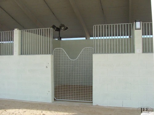 Overhead view of mint green stall fronts with curved cutout mesh panels and vertical bar upper sections