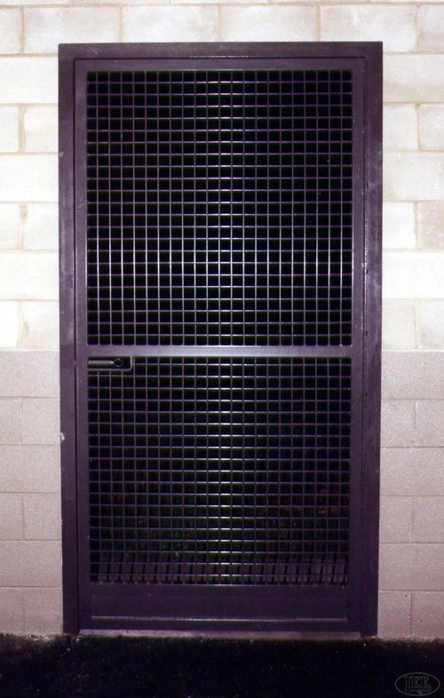 Purple metal door panel with black grid mesh pattern mounted on light colored wall