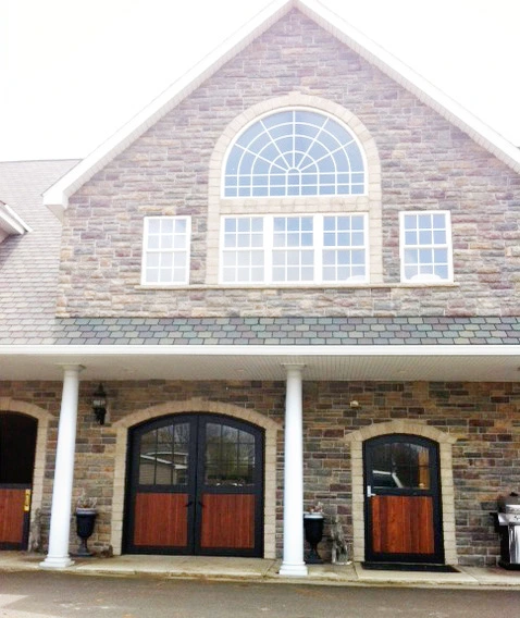Red brick building with white trim and arched double doors with fanlights