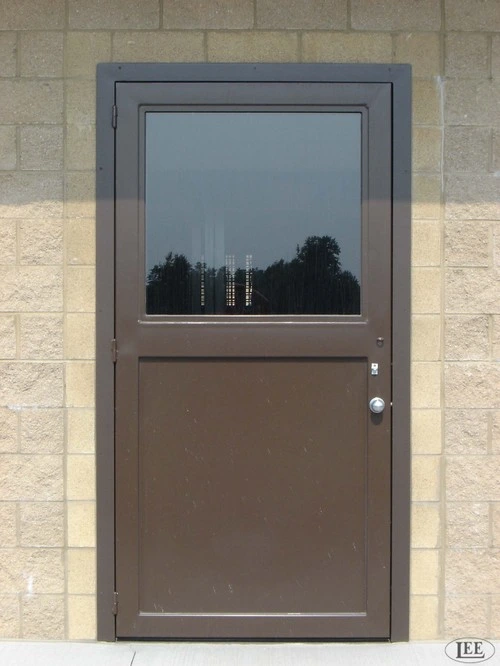 Taupe metal door with large upper window panel on limestone block wall