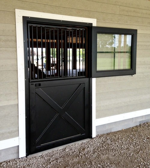 Black metal Dutch door with X-pattern lower panel on cream colored stucco wall