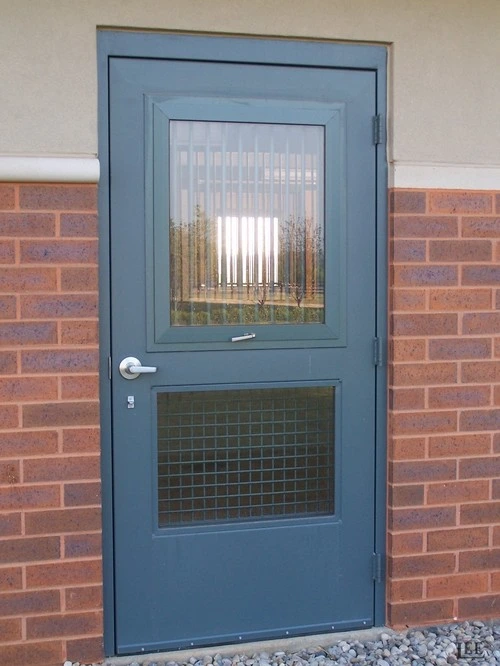 Slate blue Dutch door with upper window and wire mesh lower panel on red brick exterior