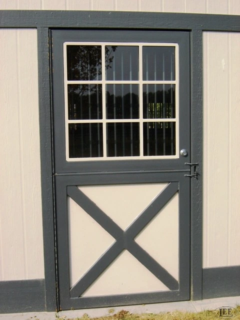 Gray metal Dutch door with multi-pane window upper section and X-brace lower panel on beige wall