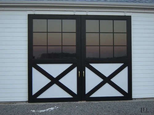 Black metal framed doors with X-brace pattern on light blue horizontal siding