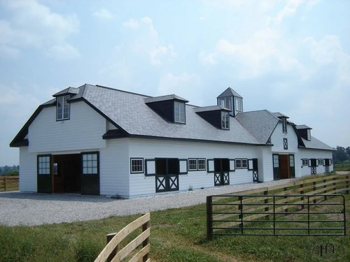 White barn exterior with black X-pattern sliding doors and dormer windows