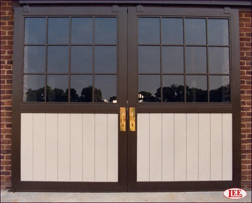 Chocolate brown doors with upper glass panel sections on red brick building exterior