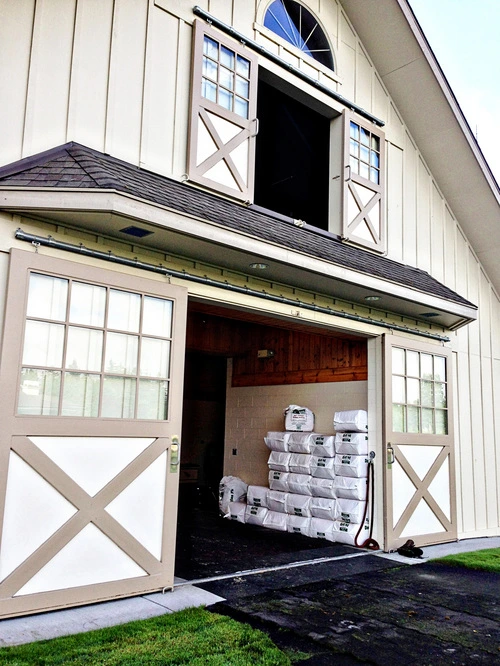 White barn with mahogany sliding door and multi-pane windows flanking entrance