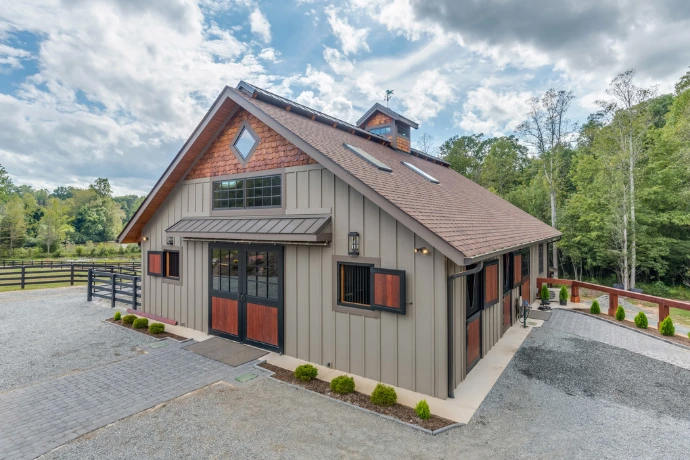 Alternate view of gray barn exterior showing varied window types and architectural features