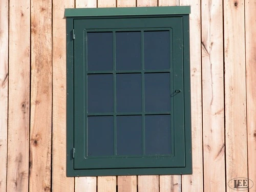 Dark teal painted window with grid pattern on natural light wood vertical siding