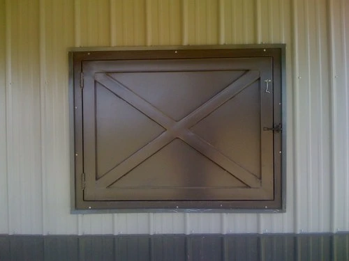 Light wood sliding window with X-brace diagonal design on tan corrugated metal wall