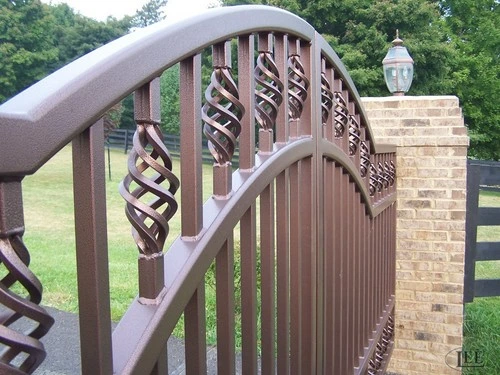 Close-up detail of twisted decorative scrollwork on cream and brown ornamental gate panel