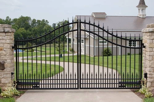 Black metal double gates with arched tops centered between tall stacked stone pillars