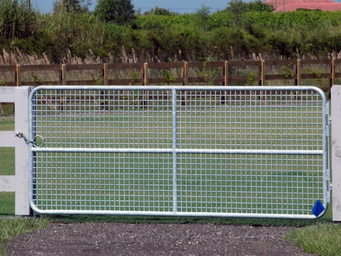 White galvanized double gate with wire mesh panels displayed on grass with vineyard backdrop