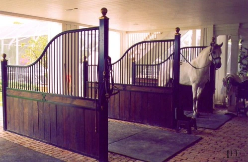 Purple or burgundy painted ornamental Dutch doors with mahogany lower panels, handlers with horses visible in barn aisle