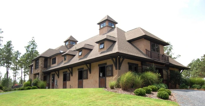 Timber-frame barn with stone pillars, multiple dormers and covered walkways