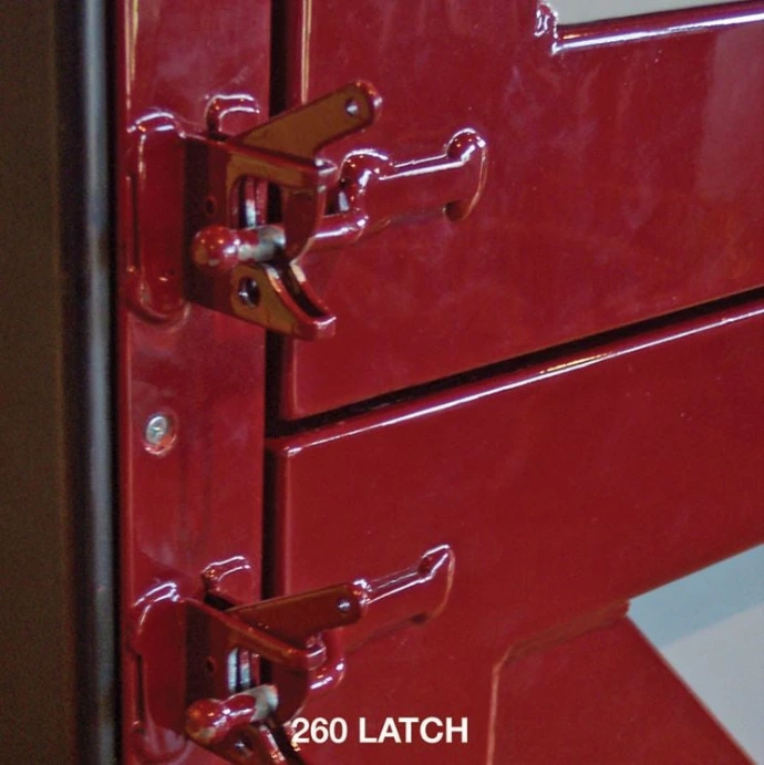 260 LATCH: Close-up of red powder-coated 260 latch hardware with dual mounting brackets on red metal stall door
