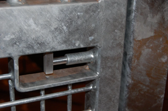 Flush Mount Latch: Galvanized metal flush mount latch mechanism recessed into concrete or stone wall surface