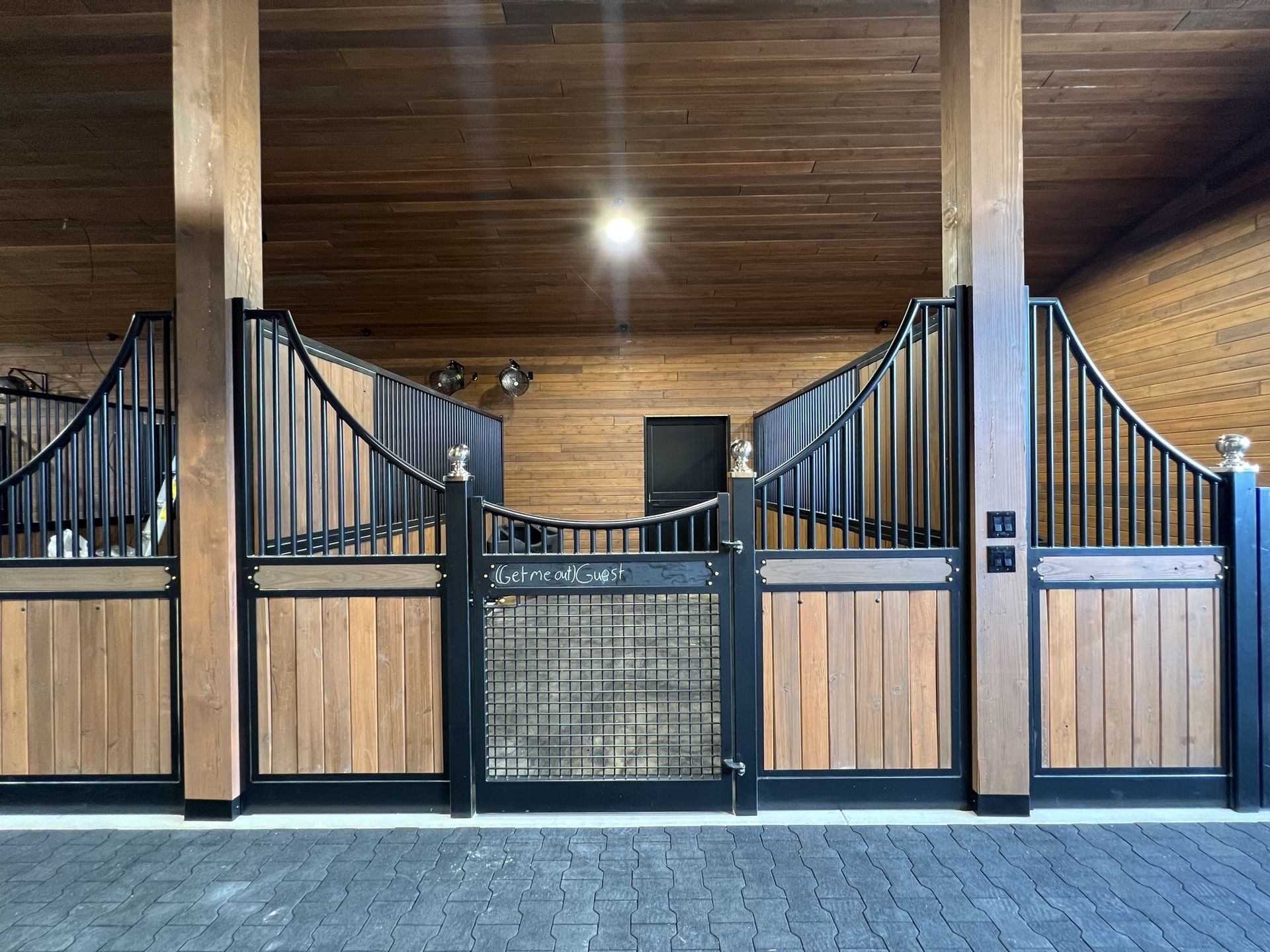 How to Get Started - Step 1 (Find your look): Modern barn aisle with black metal arched stall fronts, natural wood lower panels and upper level visible in background