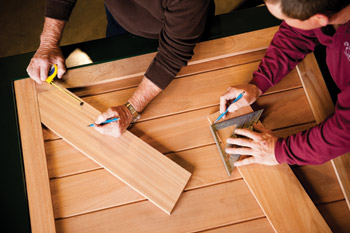 How to Get Started - Step 2 (Get an estimate): Overhead view of hands working with design materials, color samples and measuring tools on natural wood surface