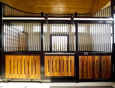 Vented Wood Fill: Natural wood stall front with black metal frame, vented vertical lumber lower panels with spacing and wire mesh upper grills