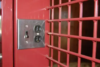 Red crosshatch mesh of a horse stall door